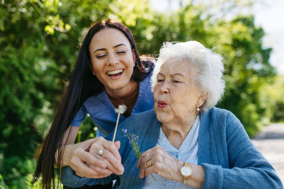 Aidante accompagnant une dame âgée dans son jardin, image de la protection des majeurs vulnérables