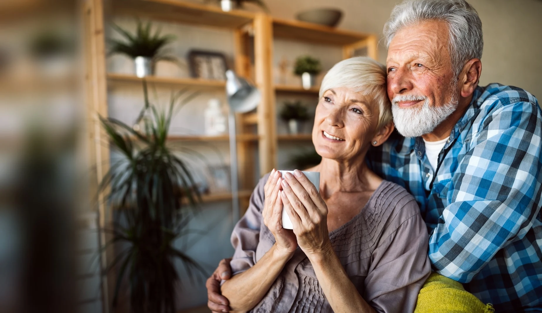 Couple de seniors complices chez eux, sereins dans leur logement