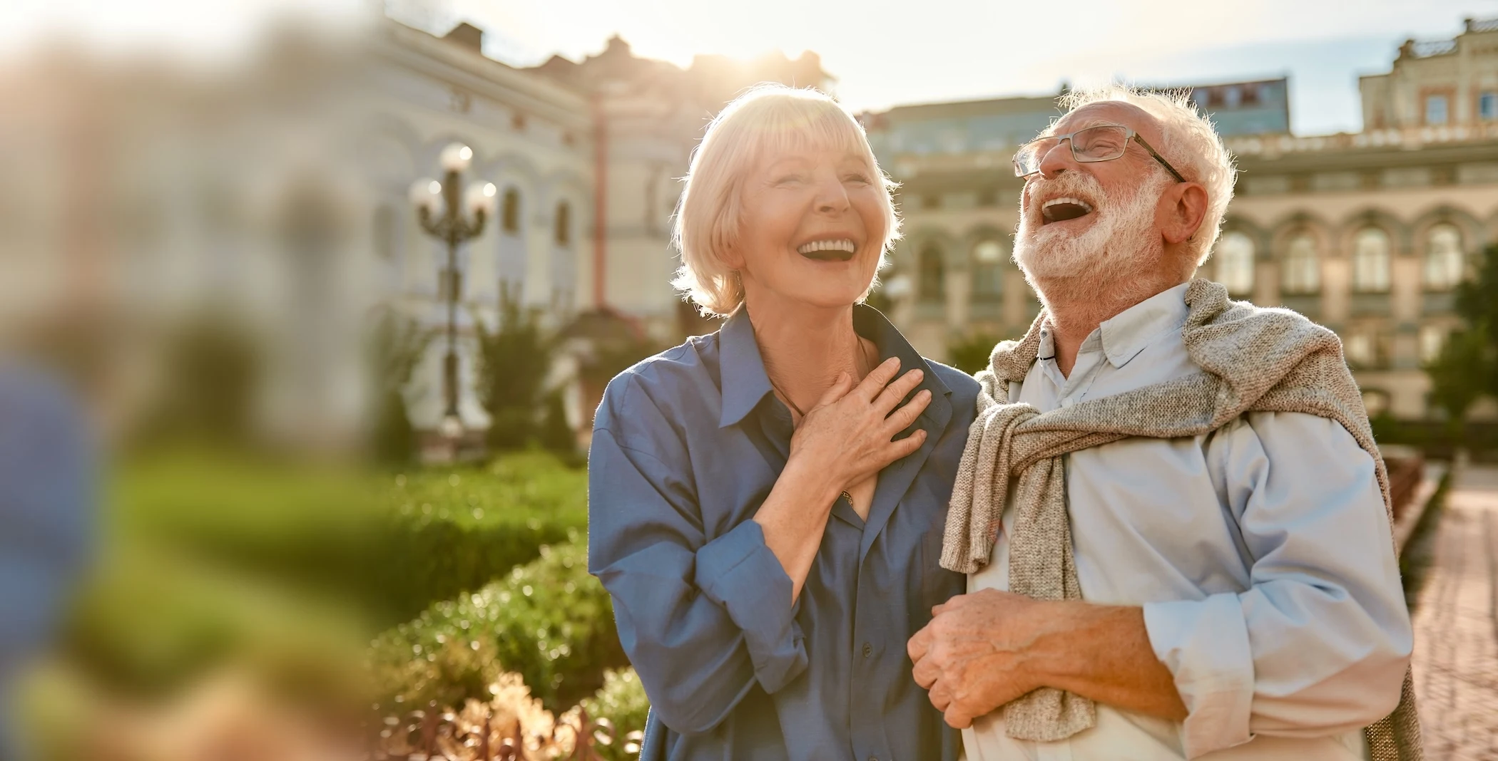 Couple de seniors riant ensemble en ville, à la lumière du soir