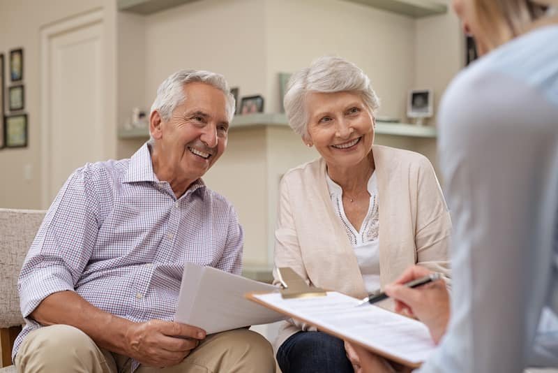 Couple de seniors signant leur vente en viager avec un conseiller Rochat Viagers